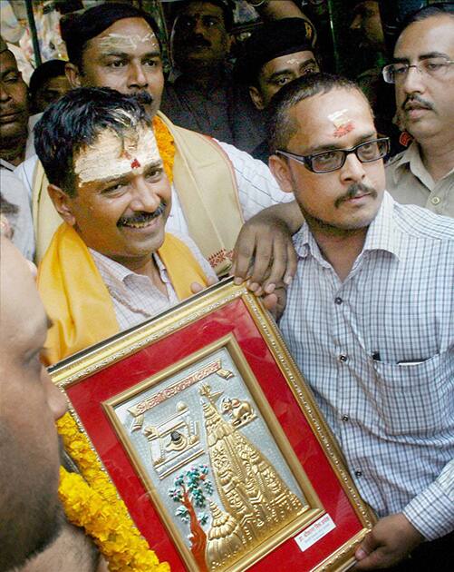 Arvind Kejriwal is presented a memento during a visit to the Kashi Vishwanath temple in Varanasi.
