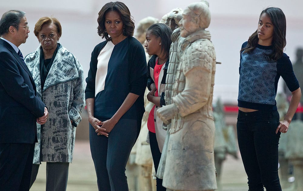 US first lady Michelle Obama looks at a terracotta warrior as she visits Qinshihuang Terracotta Warriors and Horses Museum with her daughters, Malia, right, and Sasha, second right, and her mother, Marian Shields Robinson, second left, in Xi`an, in northwestern China`s Shaanxi province.