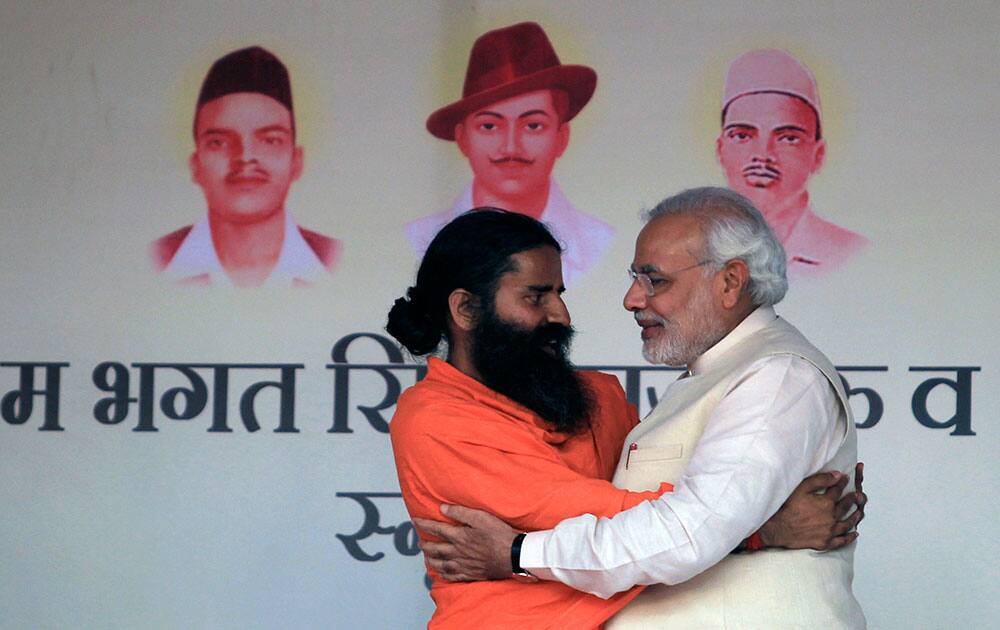 India’s opposition Bharatiya Janata Party (BJP)’s prime ministerial candidate Narendra Modi, right and Indian yoga guru Baba Ramdev, left, greet each other during a yoga festival in New Delhi.