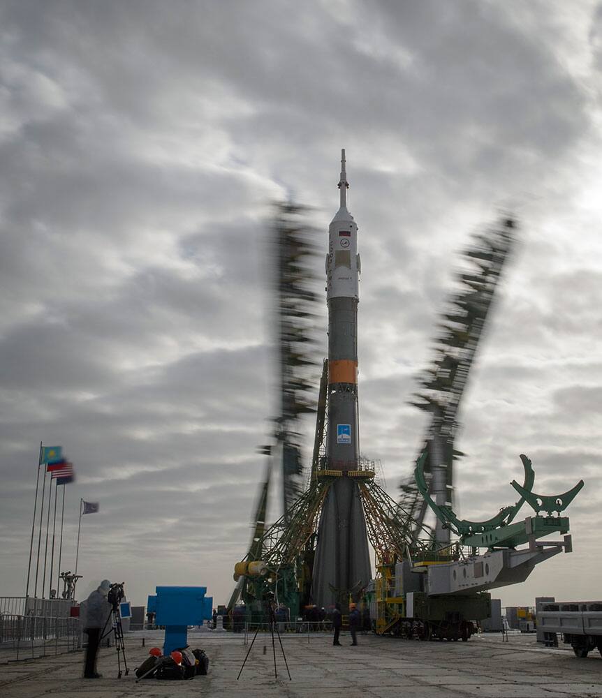 This photo provided by NASA, the gantry arms begin to close around the Soyuz TMA-12M spacecraft to secure the rocket, as seen in this long exposure photograph, at the launch pad at the Baikonur Cosmodrome in Kazakhstan.