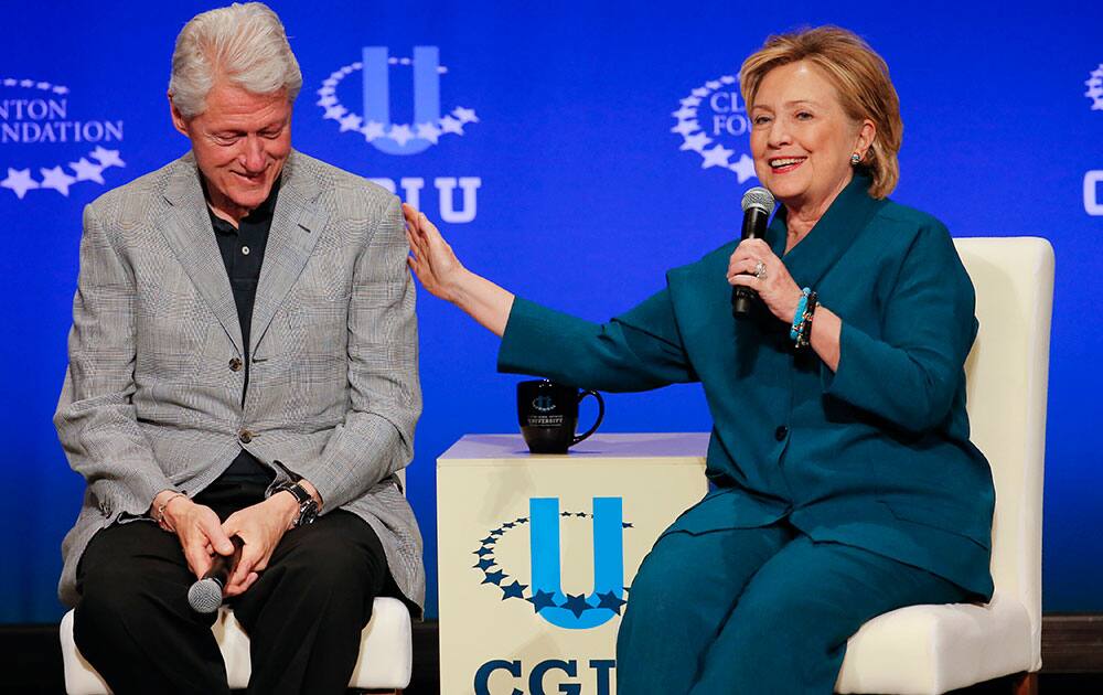 Former President Bill Clinton, left, listens as former Secretary of State Hillary Rodham Clinton speaks during a student conference for the Clinton Global Initiative University, at Arizona State University in Tempe, Ariz. More than 1,000 college students are gathered at Arizona State University this weekend as part of the Clinton Global Initiative University`s efforts to advance solutions to pressing world challenges.