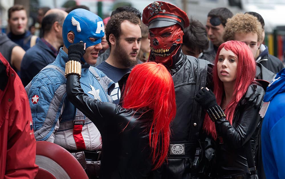 Fans dressed in Captain America character costumes wait in line outside a cinema in Madrid, Spain.