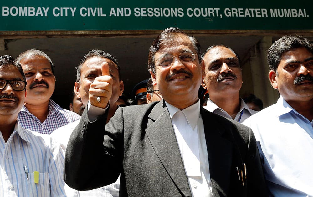 Special Public Prosecutor Ujjwal Nikam displays the victory symbol as he comes out of a court in Mumbai. The Indian court sentenced four men to life in prison on Friday for raping a call-center operator last year inside an abandoned textile mill in the financial hub of Mumbai.