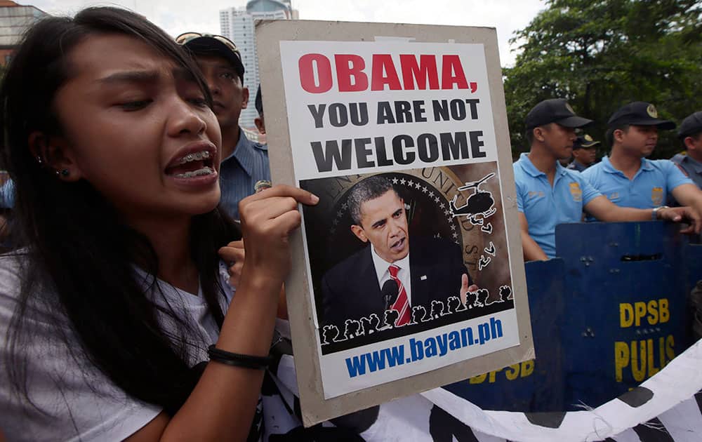 A protester displays a placard during a rally near the US Embassy in Manila, Philippines to protest the forthcoming Asian visit of President Barack Obama that includes the Philippines.