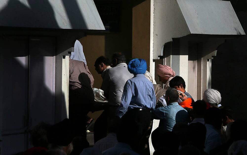 Relatives and friends of Khushwant Singh carry his body into an electric crematorium, in New Delhi.