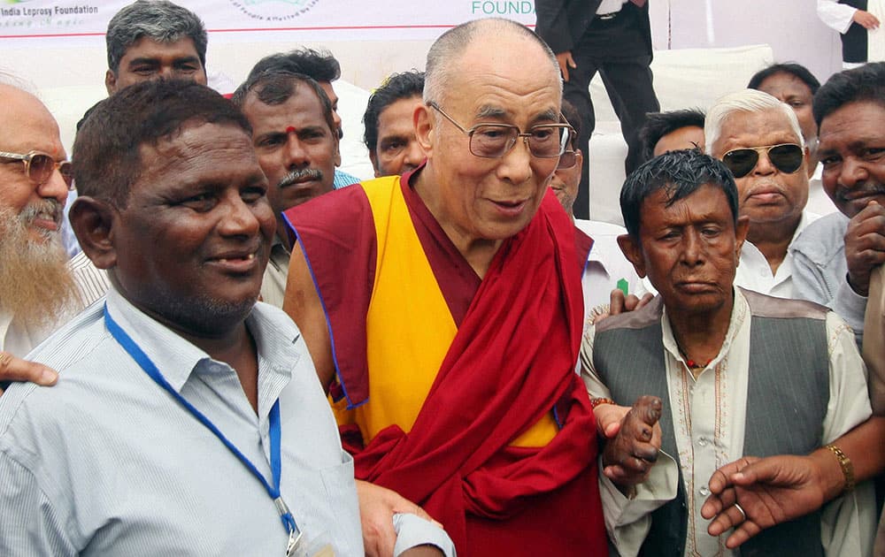 Tibetan spiritual leader the Dalai Lama pose with suffering from leprosy peoples during his visit to Tahirpur Leprosy complex, in New Delhi.