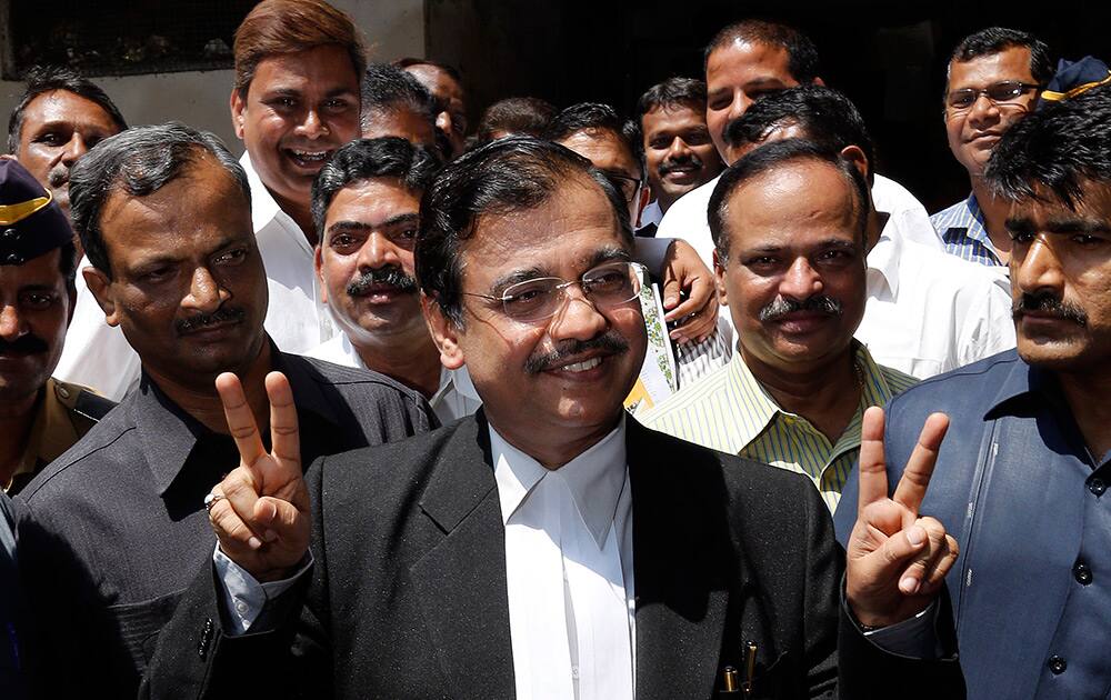 Special Public Prosecutor Ujjwal Nikam flashes victory signs outside a court after the conviction of four men in the gang rape of a photojournalist in India`s financial capital last year, in Mumbai.