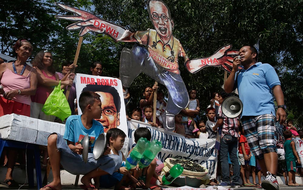 Informal settlers and their families display placards as they hold a `noise barrage` protest at suburban Navotas north of Manila, Philippines to protest the possible demolition of their shanties which allegedly sits along the expansion of the highway.