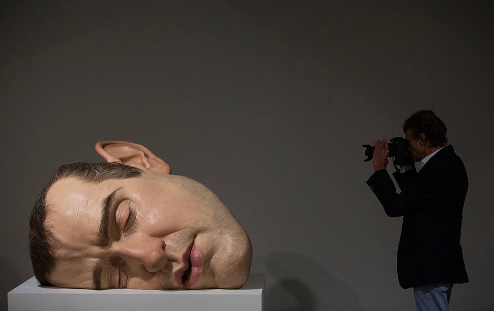 A man photographs a sculpture entitled `Mask II` by Australian artist Ron Mueck during the opening day for for exhibition at the Museum of Modern Art in Rio de Janeiro, Brazil.