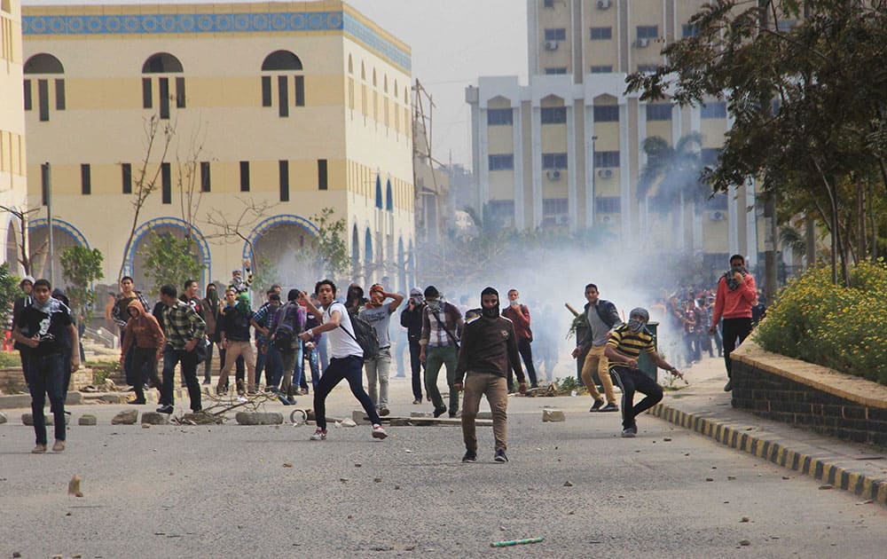 Student protesters throw rocks as Egypt`s security forces fire tear gas towards them at Al-Azhar University in Cairo, Egypt.