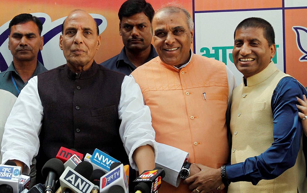 Former Congress leader Jagdambika Pal and popular comedian Raju Srivastava with BJP President Rajnath Singh after they joined BJP at party headquarters in New Delhi.