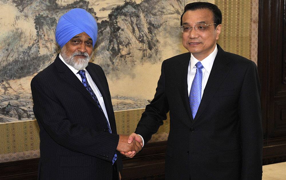 Chinese Premier Li Keqiang, right, shakes hands with Indian Planning Commission Deputy Chairman Montek Singh Ahluwalia before a meeting at the Hall of Purple Light inside the Zhongnanhai Leadership Compound in Beijing.