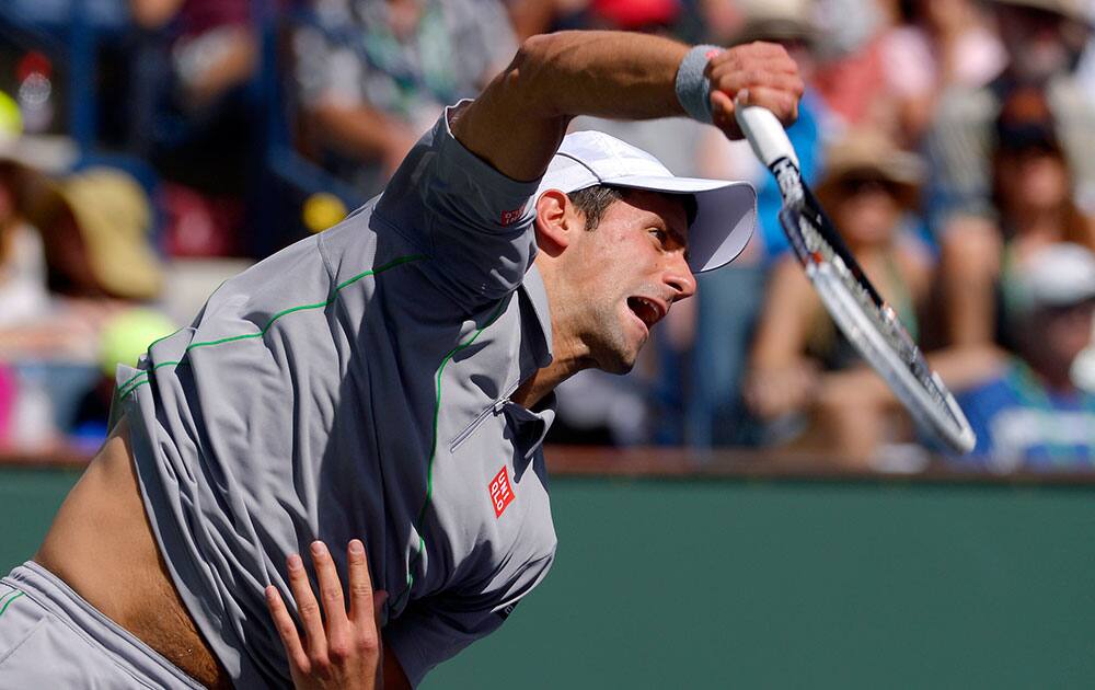Novak Djokovic, of Serbia, serves to John Isner during their semifinal at the BNP Paribas Open tennis tournament, in Indian Wells, Calif. Djokovic won 7-5, 6-7 (2), 6-1.