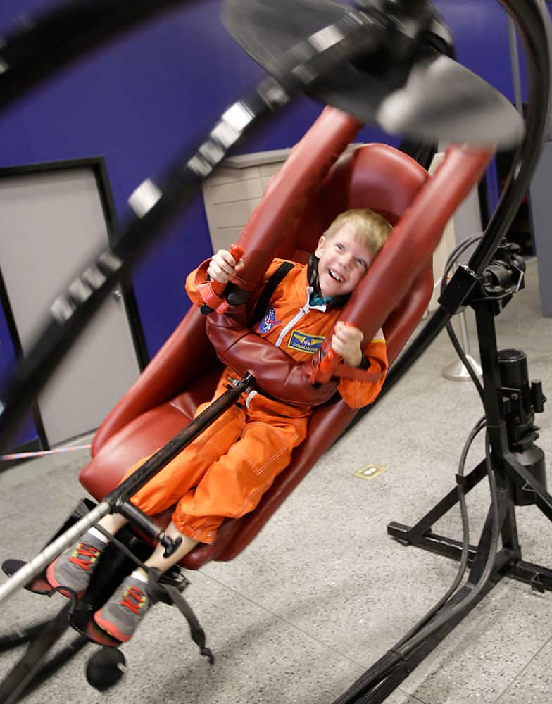 Connor Johnson, 6, of Denver, spins in circles on a multi access trainer in the Astronaut Training Experience, part of the Kennedy Space Center Visitors Complex, in Cape Canaveral, Fla.