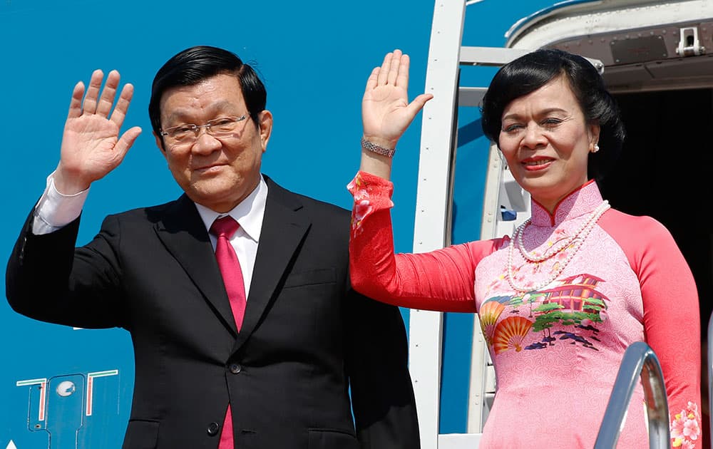 Vietnamese President Truong Tan Sang and his wife Mai Thi Hanh wave upon arrival at Haneda International Airport in Tokyo.