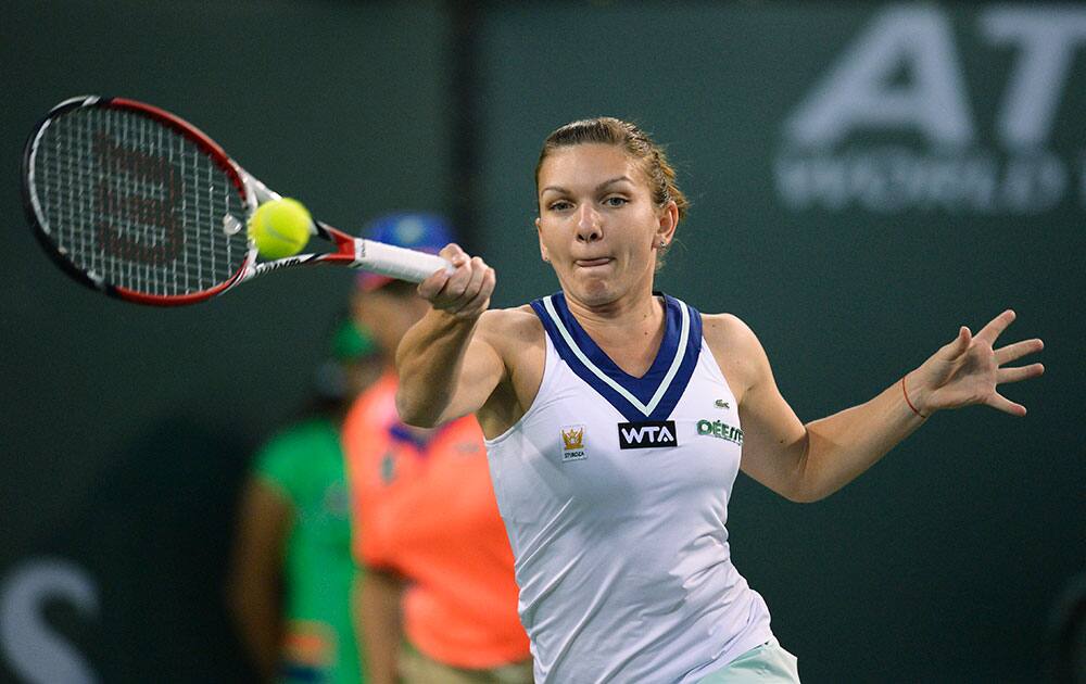 Simona Halep, of Romania, hits to Agnieszka Radwanska, of Poland, during their semifinal match at the BNP Paribas Open tennis tournament.