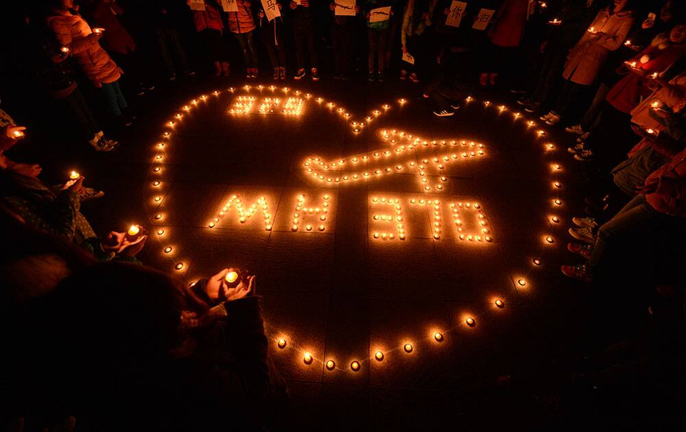 University students hold a candlelight vigil for passengers on the missing Malaysia Airlines Flight 370 in Yangzhou, in eastern China`s Jiangsu province.