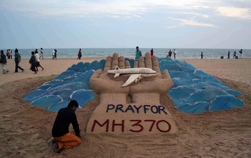 Sand artist Sudarshan Pattnaik creates a sculpture depicting the missing Malaysian Airlines aircraft on the beach in Puri, India.