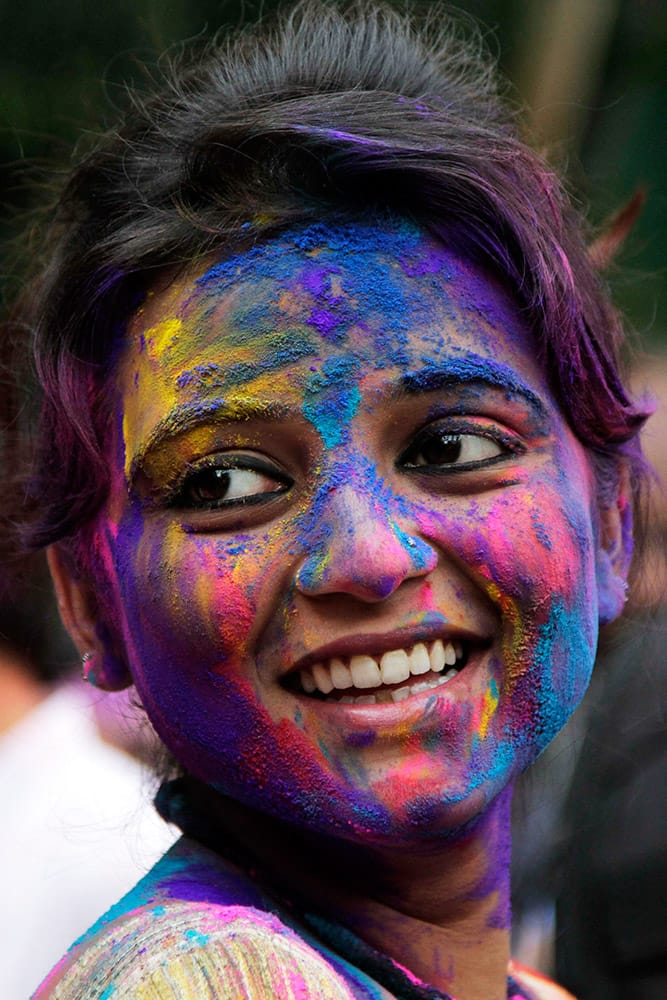 A student of Rabindra Bharati University smile with her face smeared with colored powder during spring festival celebrations in Kolkata, India.