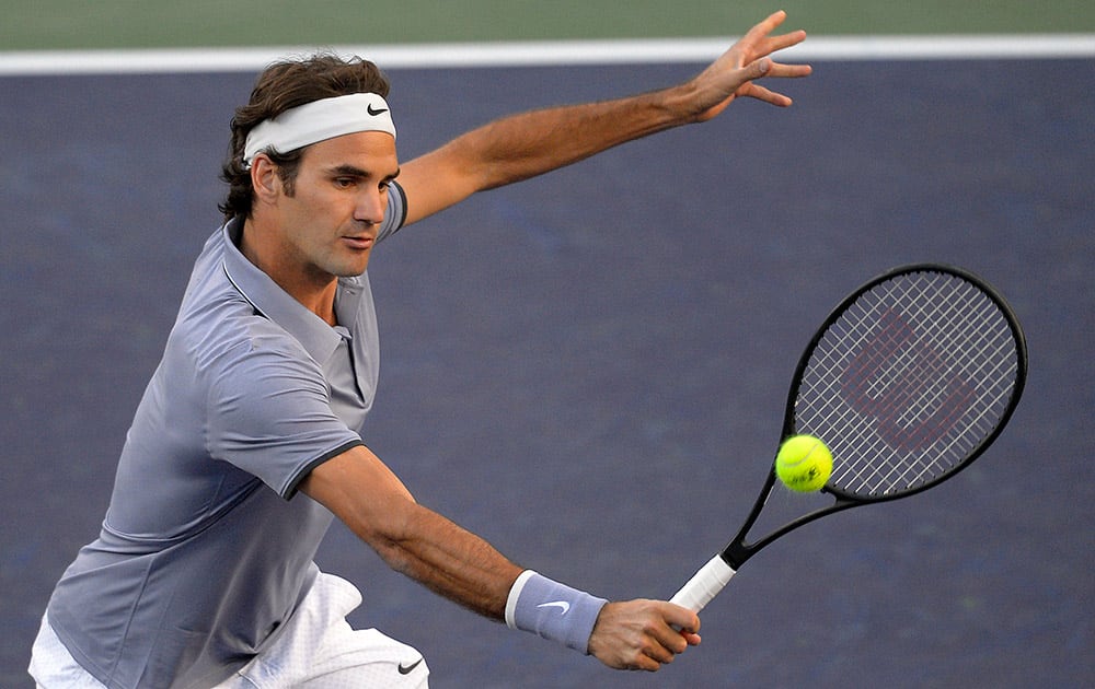 Roger Federer, of Switzerland, returns a shot against Tommy Haas, of Germany, during a fourth round match at the BNP Paribas Open tennis tournament.