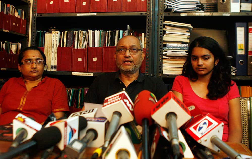 Narendran, husband of one of the passengers of the missing Malaysia Airlines aircraft Chandrika Sharma, speaks to the media with their daughter Meghna, right, sitting beside in Chennai.