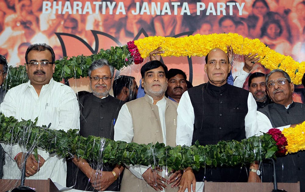 BJP President Rajnath Singh with Former RJD leader Ram Kripal Yadav being garlanded during the latter`s joining the Bharatiya Janata Party in New Delhi.