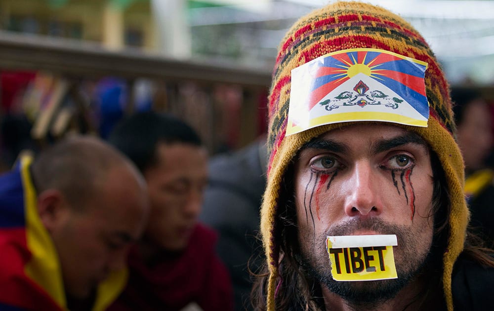 Austrian national Maximilian with a Tibetan flag attached to his hat joins exiled Tibetans at a gathering to mark the 55th anniversary of the failed uprising in the Tibetan capital Lhasa in 1959, in Dharmsala, India.