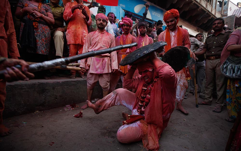A villager from Nandgaon loses his balances as a woman from Barsana village hits him with a wooden stick during the Lathmar Holy festival the legendary hometown of Radha, consort of Hindu God Krishna, in Barsana, 115 kilometers (71 miles) from New Delhi, India.