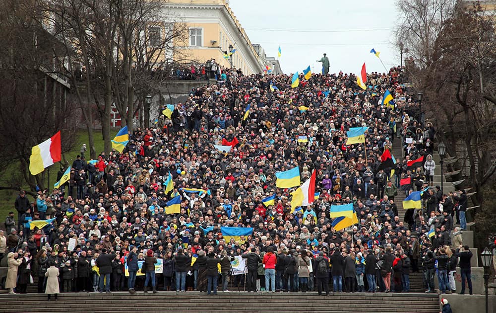 Ukrainians sing the national anthem waving national flags during an anti-war protest on the Potemkin Stairs considered a formal entrance into the city from the direction of the sea and the best known symbol of the Black Sea port of Odessa, Ukraine.