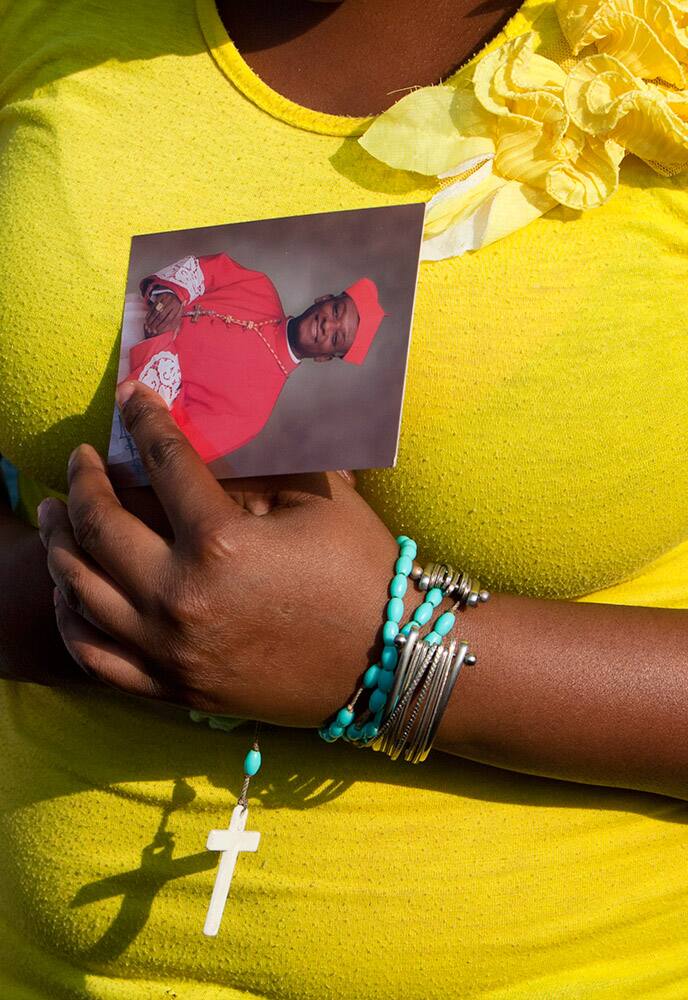 A woman holds a picture of newly appointed Cardinal Chibly Langlois as she attends Mass in Port-au-Prince, Haiti.