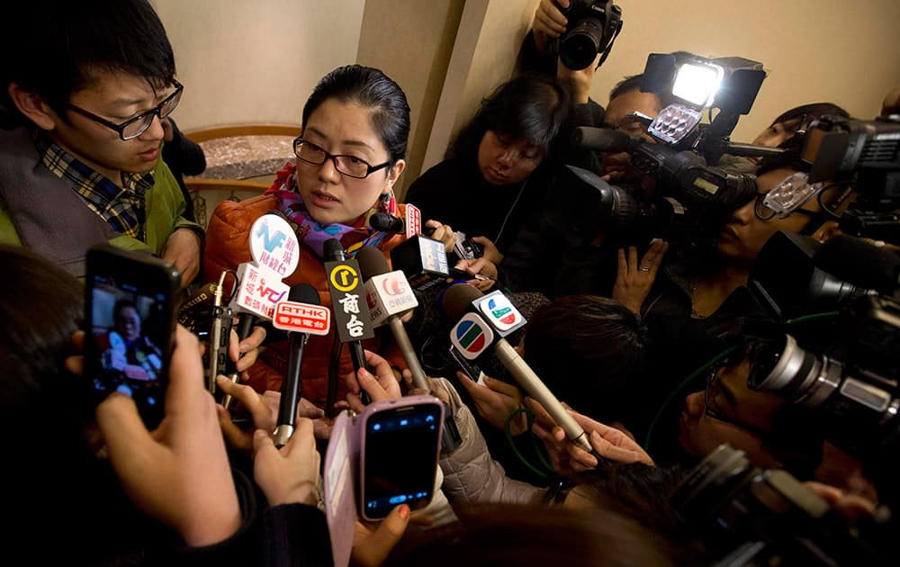 A Chinese woman who identified herself as Miss Nan, whose husband and brother where among the passengers aboard a missing Malaysia Airlines plane speaks to the media outside a hotel room for relatives or friends of passengers aboard the missing airplane, in Beijing, China.