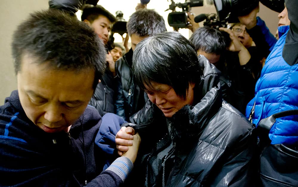 A Chinese relative of passengers aboard a missing Malaysia Airlines plane cries as she leaves a hotel room for relatives or friends of passengers aboard the missing airplane, in Beijing, China.