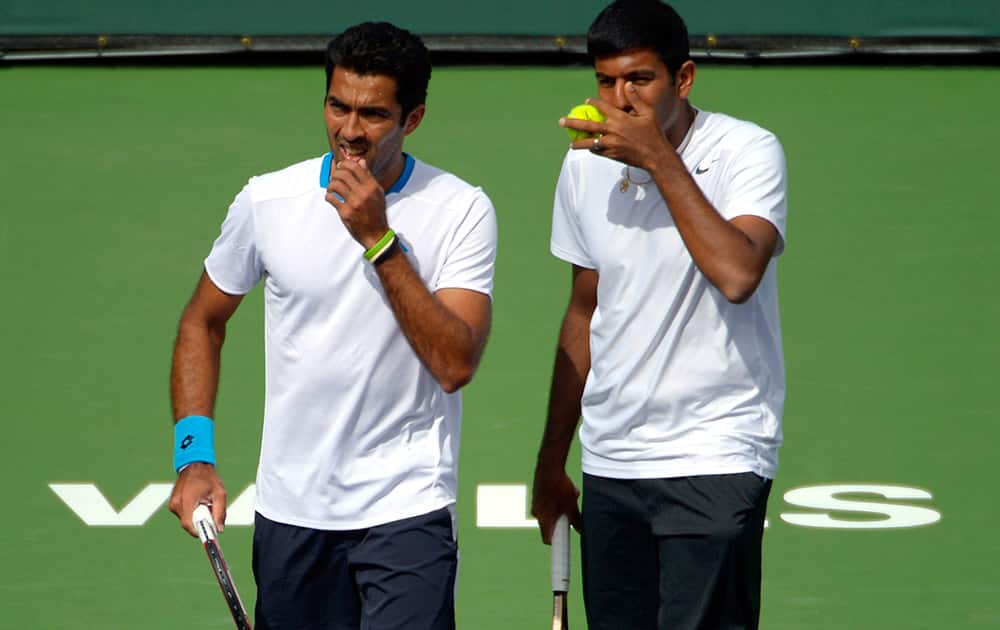 Aisam-Ul- Haq Qureshi, left, of Pakistan, and Rohan Bopanna, of India, talk between points as they play Switzerland`s Roger Federer and Stanislas Wawrinka in a doubles match at the BNP Paribas Open tennis tournament in Indian Wells, Calif.