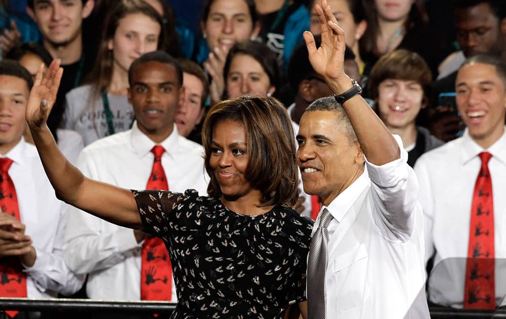 President Barack Obama and first lady Michelle Obama wave in the gym at Coral Reef High School, in Miami.
