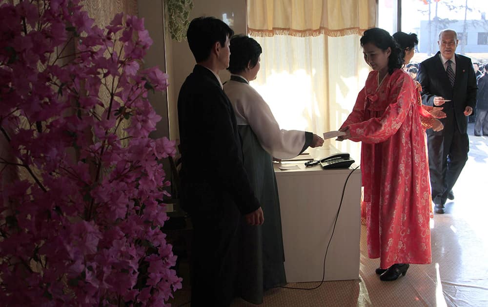 A woman receives a ballot to vote to elect deputies to the 13th Supreme People`s Assembly in Pyongyang, North Korea.