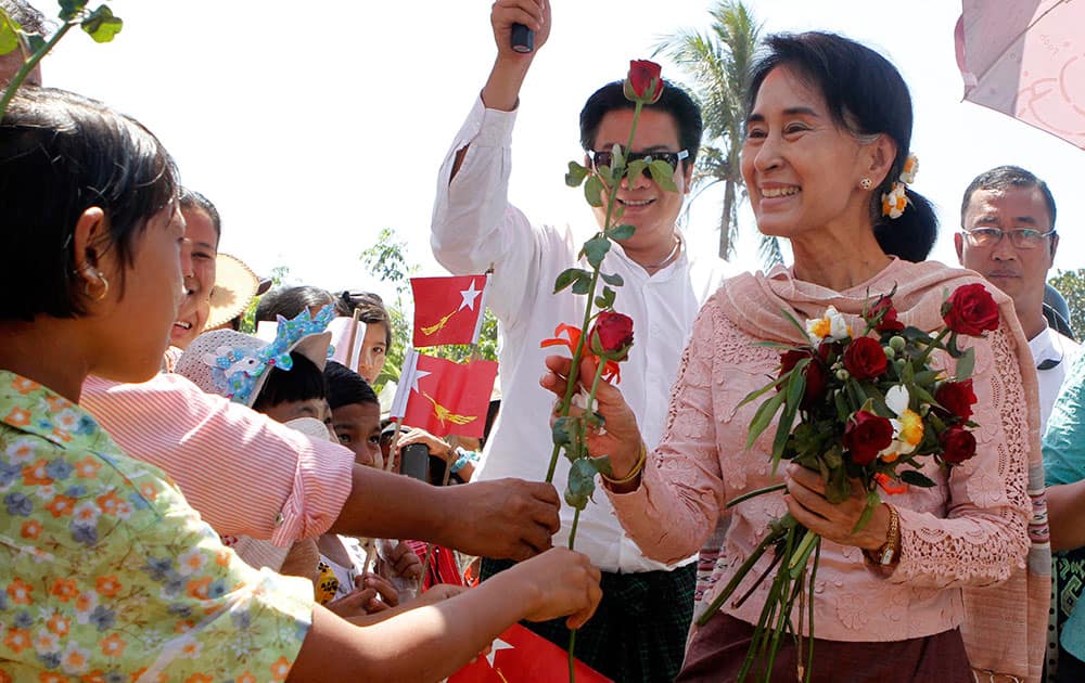 Myanmar opposition leader Aung San Suu Kyi receives flowers from children as she visits a library of Daw Khin Kyi Foundation at Kaw Hmu, her constituency in Yangon, Myanmar.