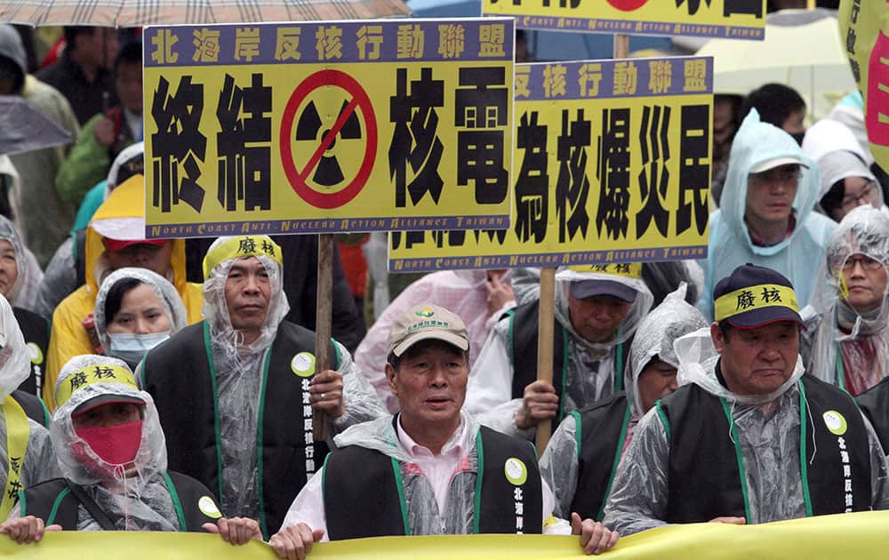 Taiwanese protesters living close to a nuclear power plant hold slogan reading `Stop Nuclear Energy` during a protest to demand that the government stop the 4th nuclear power plant that is nearly complete in Taipei, Taiwan