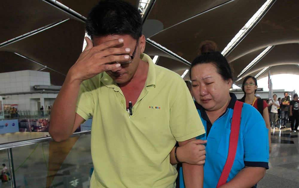 A woman cries as she walks out of the reception center and holding area for family and friend of passengers aboard a missing Malaysia Airlines plane, at Kuala Lumpur International Airport in Sepang, outside Kuala Lumpur, Malaysia.