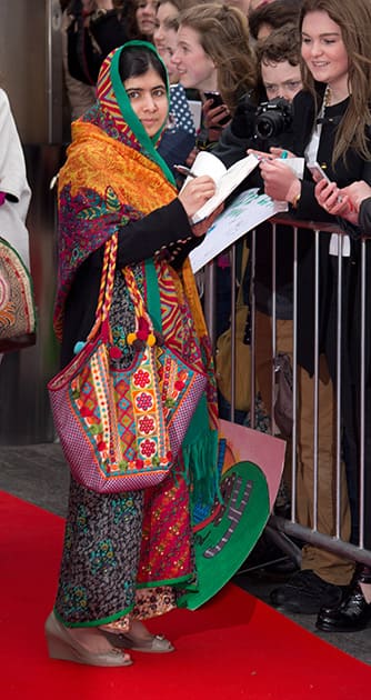 Pakistani educational activist Malala Yousafzai, signs autographs as she arrives for We Day at Wembley Arena in London.