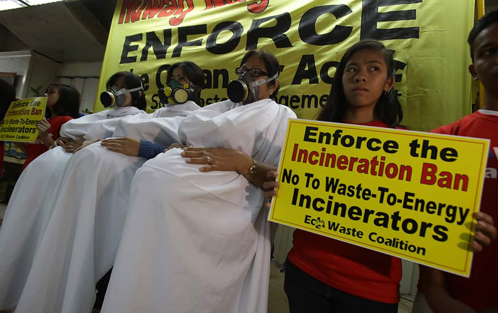 Filipino activists dressed as pregnant women wearing gas mask pose during a protest as part of their observance of International Women`s Day in suburban Quezon city, north of Manila, Philippines.