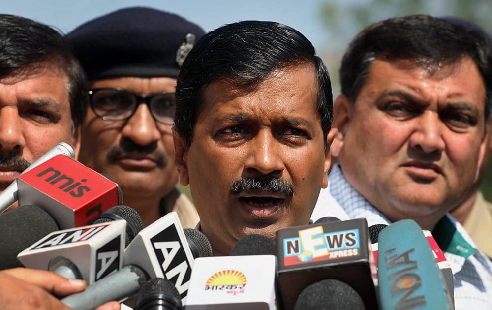Arvind Kejriwal addresses media before leaving to meet Gujarat state Chief Minister Narendra Modi, in Ahmadabad.