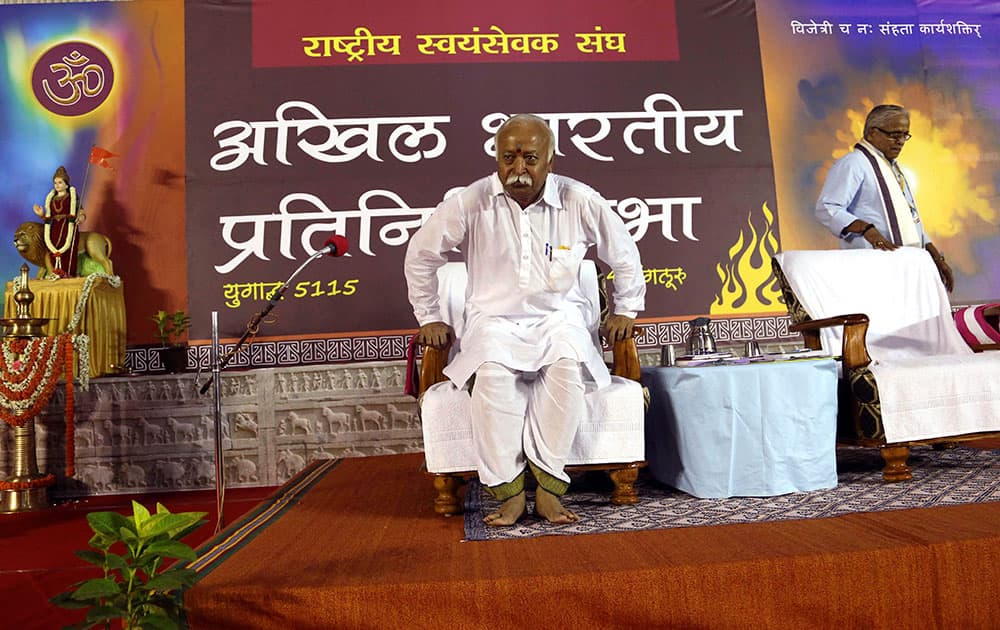 Hindu nationalist Rashtriya Swayamsevak Sangh (RSS), or the National Volunteers Force chief Mohan Bhagwat, left, takes his seat during a meeting of their organization in Bangalore.