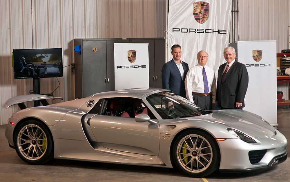This photo provided by the Georgia Ports Authority, Port of Brunswick Global Manager, Bill Jakubsen, Port of Brunswick General Manager of Operations Bill Dawson and Porsche`s Manager of Vehicle Logistics and Port Operations Justin Newell, stand near the first shipment of Porsche 918 Spyder automobile at the the Georgia Ports Authority Colonel’s Island Terminal at the Port of Brunswick.