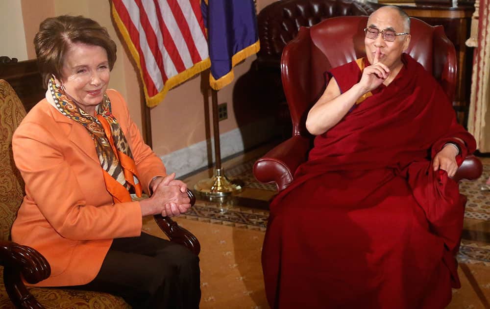 Tibetan spiritual leader the Dalai Lama gestures towards a reporter asking a question as he meets with House Speaker John Boehner of Ohio and House Minority Leader Nancy Pelosi of Calif., on Capitol Hill in Washington.