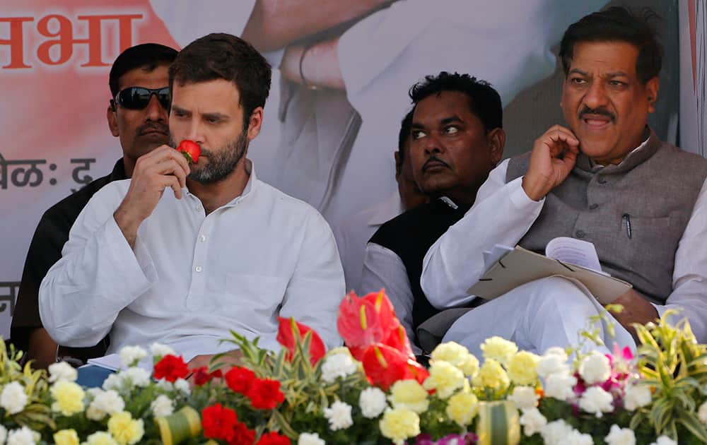 Rahul Gandhi, smells a rose that was presented to him during an election campaign rally in Thane, outskirts of Mumbai.