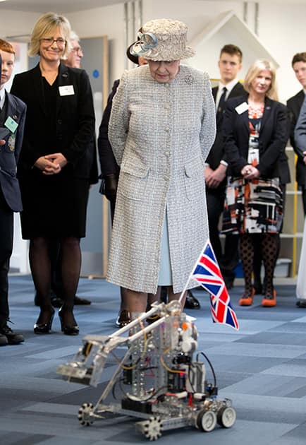 Britain`s Queen Elizabeth II looks at a robotic demonstration as she visits Reed`s School, in Cobham, England.