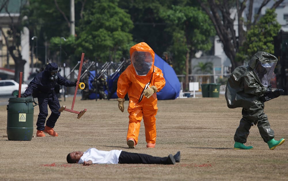 Filipino troopers from the Explosive Ordnance Disposal Division wearing chemical suits check on a victim during a mock attack as part of the 1st Global Terrorism and Chemical, Biological, Radiological and Nuclear explosives Conference at Camp Aquinaldo military headquarters in suburban Quezon city, north of Manila, Philippines .