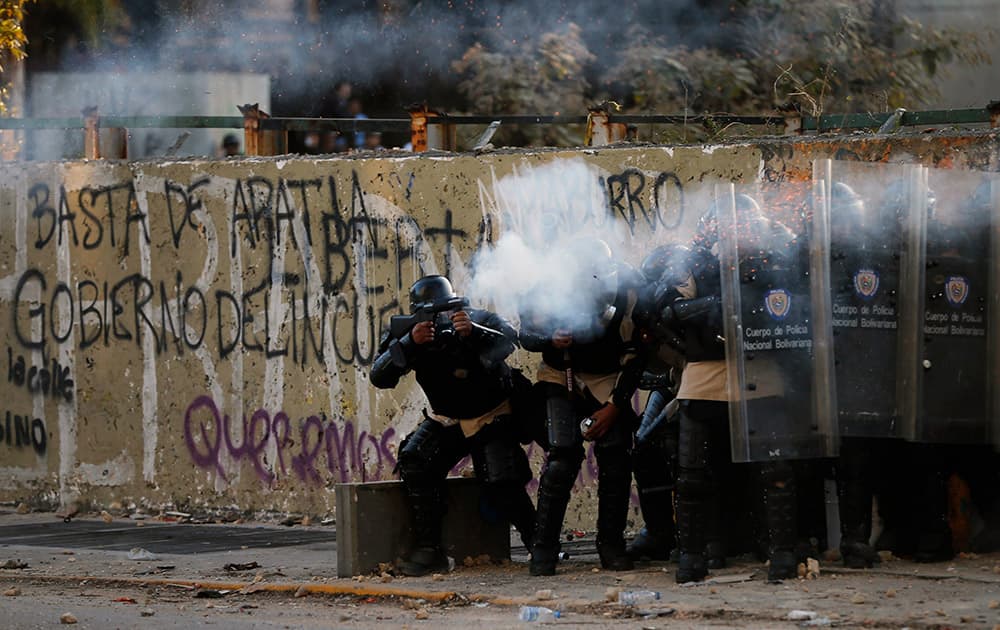 Bolivarian national police officers fire teargas at demonstrators during clashes in Caracas, Venezuela.