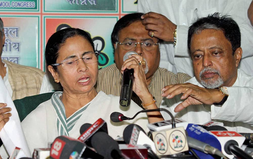 Trinamool Congress Supremo and West Bengal Chief Minister Mamata Banerjee with State Finance Minister Amit Mitra( L)Formar Railway Minister and TMC General Sccretary Mukul Roy (R) announces candidates forLok Sabha elections at a press conference in Kolkata.