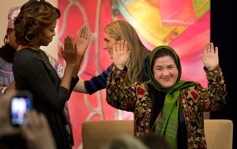 First lady Michelle Obama applauds Dr. Nasrin Oryakhil, of Afghanistan, right, a leader in the field of maternal health, as she is honored with a 2014 International Women of Courage award during a ceremony at the State Department in Washington.